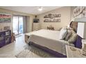 Spacious main bedroom with a plush bed, dresser, and access to a private outdoor patio at 10624 W Oakmont Dr, Sun City, AZ 85351