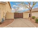 Exterior shot of a home showcasing a concrete driveway leading up to a wood driveway gate and the side of the house at 1165 E Erie St, Gilbert, AZ 85295