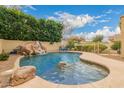 Backyard pool with rock waterfall feature and slide at 1165 E Erie St, Gilbert, AZ 85295