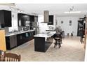 Spacious kitchen featuring dark cabinets, stainless steel appliances, and marble-topped island at 13219 W Aleppo Dr, Sun City West, AZ 85375