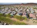 Expansive aerial shot showcases home with solar panels and a pool, nestled in a scenic community at 13529 W Remuda Dr, Peoria, AZ 85383