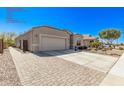 Charming front exterior features a paved driveway, mature trees and plants, and an attached guest quarters on the side at 13529 W Remuda Dr, Peoria, AZ 85383