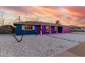 Single-story home featuring gravel landscaping, striking blue exterior, and pink garage door at 1435 W 6Th St, Mesa, AZ 85201