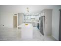 Bright kitchen featuring white cabinets, stainless steel appliances, and a center island with quartz countertops at 1610 W Dunlap Ave, Phoenix, AZ 85021