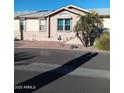 Exterior front view of home featuring neutral paint, walkway, palm trees and desert landscaping at 17200 W Bell Rd # 2301, Surprise, AZ 85374