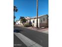 Street view of tan homes with palm trees and desert landscaping at 17200 W Bell Rd # 2301, Surprise, AZ 85374