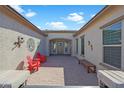 Charming courtyard with brick pavers, Adirondack chairs, bench, and decorative wall art at 18601 W Thunderhill Pl, Goodyear, AZ 85338