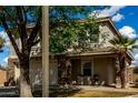 Charming two-story home featuring a two-car garage and a welcoming covered porch with seating area at 2562 E Oxford Ct, Gilbert, AZ 85295