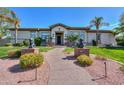 Inviting front entrance featuring a well-manicured walkway, desert landscaping, and decorative statues at 3527 E Indigo Cir, Mesa, AZ 85213