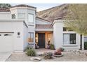 Beautiful home entrance with manicured desert landscaping, potted plants, and a charming front door at 6348 W Hill Ln, Glendale, AZ 85310