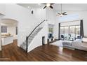 Bright living room with staircase, wood floors, high ceilings, modern furniture, and a view to the backyard at 6348 W Hill Ln, Glendale, AZ 85310