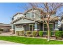 Attractive two-story home featuring a covered porch, well-manicured lawn, and mature tree at 7540 E Pampa Ave, Mesa, AZ 85212