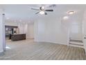 Open-concept living room features tile flooring, ceiling fan, and staircase to the upper level at 7769 W Bonitos Dr, Phoenix, AZ 85035