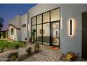 Inviting front entrance featuring a glass door, desert landscaping, and stylish outdoor seating at 8319 E Columbus Ave, Scottsdale, AZ 85251