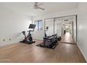 The bright bedroom area features a mirrored closet, hardwood floors, and workout equipment at 9125 E Purdue Ave # 214, Scottsdale, AZ 85258