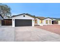 Single-story home showcasing a tidy lawn, painted brick, and two car garage at 918 W Carmen St, Tempe, AZ 85283