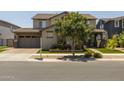 Charming two-story home with a tan exterior, manicured lawn, and inviting curb appeal at 10713 E Tesla Ave, Mesa, AZ 85212