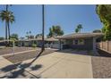 View of charming single-story home with a covered carport and desert landscaping at 10844 N 37Th St, Phoenix, AZ 85028