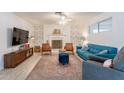 Bright living room featuring a decorative fireplace, stylish furniture, and wood-look tile flooring at 10844 N 37Th St, Phoenix, AZ 85028