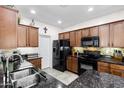 Modern kitchen featuring dark appliances, stone countertops, and plenty of cabinet space for storage at 1475 N Agave St, Casa Grande, AZ 85122