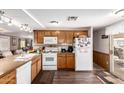 Traditional kitchen with wooden cabinets, white appliances, and dark wood floors at 1779 S 74Th St, Mesa, AZ 85209