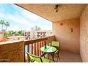Cozy balcony with views of the pool, outdoor table with chairs, and a bottle of wine for outdoor relaxation at 3031 N Civic Center Plz # 306, Scottsdale, AZ 85251