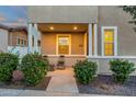 Inviting front porch featuring a cozy seating area, decorative plants, and warm lighting at 3802 E Stiles Ln, Gilbert, AZ 85295