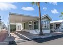 Charming mobile home with green siding, mature palm trees, and a convenient covered carport at 400 Hawks Eye Dr, Apache Junction, AZ 85119
