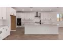 Bright kitchen with white cabinets, stainless steel appliances, and large island with sink at 40563 W Michaels Dr, Maricopa, AZ 85138