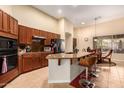 Open kitchen with bar seating, dark cabinets, granite counters, and modern appliances at 4192 E Carriage Way, Gilbert, AZ 85297