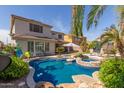 Backyard pool with rock features, palm trees, patio furniture, and attached spa at 502 E Kona Dr, Casa Grande, AZ 85122
