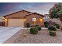 Charming single-story home with a two-car garage, desert landscaping, and a warm, inviting facade at 631 W Stanley Ave, San Tan Valley, AZ 85140