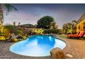 Backyard swimming pool with waterfall feature and manicured landscaping at 631 W Stanley Ave, San Tan Valley, AZ 85140