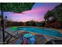 Backyard pool with lounge chairs, shade and lush landscaping provides a relaxing outdoor retreat at 7102 W Wilshire Dr, Phoenix, AZ 85035