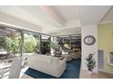 Bright living room with floor-to-ceiling windows offering views of the lush exterior at 7121 E Rancho Vista Dr # 1008, Scottsdale, AZ 85251