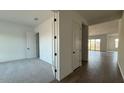 Bright hallway with wood-look tile flooring leading to an open-concept space and carpeted room at 11447 E Utah Ave, Mesa, AZ 85212