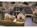 New construction aerial view of a gorgeous home in desert landscape with stone and stucco exterior and manicured lawn at 11841 N 65Th Pl, Scottsdale, AZ 85254