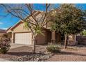 Inviting two-story home featuring a well-maintained front yard with desert landscaping and a two-car garage at 13212 W Lisbon Ln, Surprise, AZ 85379