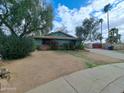 A single-story home framed by lush trees and a spacious front yard at 13805 N 31St Ave, Phoenix, AZ 85053