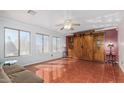 Spacious living room with wood tile flooring, a built-in storage unit, and large windows for natural light at 1805 E Aloe Pl, Chandler, AZ 85286