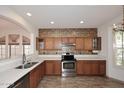 Well-lit kitchen showcasing tile floors, stainless steel appliances, and abundant cabinetry at 1839 E Donner Dr, Phoenix, AZ 85042