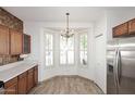 Bright eat-in kitchen with bay window, stainless steel refrigerator, and wooden cabinetry at 1839 E Donner Dr, Phoenix, AZ 85042