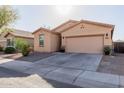 Street view of a single-story home with desert landscaping and a two-car garage at 18842 N Lariat Rd, Maricopa, AZ 85138