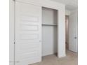 Bedroom with a spacious closet featuring white sliding doors and ample storage space at 27280 N 74Th Ln, Peoria, AZ 85383