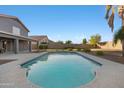 A sparkling backyard pool with a covered patio and mature landscaping at 31446 N Candlewood Dr, San Tan Valley, AZ 85143