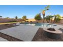 An inviting in-ground swimming pool surrounded by lush landscaping and desert plants at 31446 N Candlewood Dr, San Tan Valley, AZ 85143