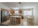 Eat-in kitchen featuring stainless steel appliances, wood cabinets, and an island with barstool seating at 3313 E Waltann Ln, Phoenix, AZ 85032