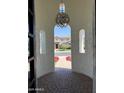 Inviting entryway featuring arched windows and a decorative light fixture, offering a glimpse of the landscaped front yard at 3675 E Strawberry Dr, Gilbert, AZ 85298