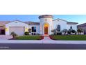 Charming stucco home with a turret, manicured lawn, and a beautiful brick walkway to the front door at 3675 E Strawberry Dr, Gilbert, AZ 85298