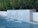 Cascading water feature on a backyard swimming pool with elegant landscaping and privacy at 3675 E Strawberry Dr, Gilbert, AZ 85298